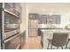 Modern kitchen showcases built in oven, stainless steel appliances, granite countertops, and large island seating at 7284 Bayview Run, McCordsville, IN 46055