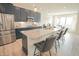 Modern kitchen features stainless steel appliances, granite countertops, and a large island with seating at 7284 Bayview Run, McCordsville, IN 46055