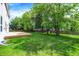 Well-manicured backyard featuring a wooden deck, mature trees, and a fenced perimeter at 7337 Wythe Dr, Noblesville, IN 46062