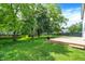 Large, well-maintained backyard with a wooden deck, lush green grass, and mature trees at 7337 Wythe Dr, Noblesville, IN 46062