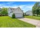 Side view of a two-story home with an attached garage, driveway, and a green lawn at 7337 Wythe Dr, Noblesville, IN 46062