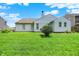 View of the back of a home with a well-maintained lawn, siding, and a chimney under a bright sky at 8038 Sydney Ln, Avon, IN 46123