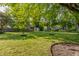 Lush backyard featuring a large lawn, mature trees, and space for outdoor activities at 8117 Scarborough Ct, Indianapolis, IN 46256