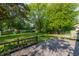 Large backyard with mature trees, green grass, and wooden deck at 8117 Scarborough Ct, Indianapolis, IN 46256