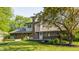 Spacious backyard featuring a well-maintained lawn, mature trees, a wooden deck, and a brick chimney at 8117 Scarborough Ct, Indianapolis, IN 46256