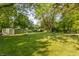 Expansive backyard featuring a storage shed, a playset, and mature trees providing ample shade at 8117 Scarborough Ct, Indianapolis, IN 46256