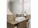 Stylish bathroom with a vessel sink, round mirror, modern vanity, and stone accent wall at 8117 Scarborough Ct, Indianapolis, IN 46256