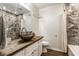 Nicely decorated bathroom featuring decorative sink bowl, full shower, and wood-look floors at 8117 Scarborough Ct, Indianapolis, IN 46256