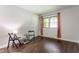 Cozy bedroom with wood-look floors, a window with orange curtains, and closet at 8117 Scarborough Ct, Indianapolis, IN 46256