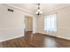 Dining area with wood flooring, a modern chandelier, and a bright window with sheer curtains at 8117 Scarborough Ct, Indianapolis, IN 46256