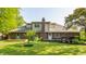 Home's backyard with brick facade, lush lawn, and mature trees at 8117 Scarborough Ct, Indianapolis, IN 46256