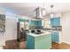 Modern kitchen featuring custom blue cabinets, stainless steel appliances, a center island, and stylish mosaic backsplash at 8117 Scarborough Ct, Indianapolis, IN 46256