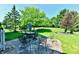 A stone patio features multiple seating areas, all surrounded by a lush, manicured lawn and beautiful landscaping at 8460 Brittany N Ct, Indianapolis, IN 46236