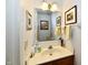 Cozy half bathroom features a vanity and marble countertop with framed art on the walls at 8460 Brittany N Ct, Indianapolis, IN 46236