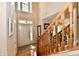 The foyer features hardwood floors, an open staircase, and a decorative stained-glass window above the front door at 8460 Brittany N Ct, Indianapolis, IN 46236