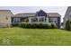 The lush green backyard features a well-maintained deck with lake views, surrounded by manicured landscaping at 8864 S Tibbs Ave, Indianapolis, IN 46217