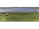 Expansive backyard with lush lawn, black chain-link fence, playground, and waterfront access with dock at 8864 S Tibbs Ave, Indianapolis, IN 46217