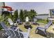 Backyard features a stone paver patio with a fire pit, surrounded by Adirondack chairs and lush landscaping at 8864 S Tibbs Ave, Indianapolis, IN 46217
