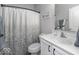 Well-lit bathroom with a classic vanity, stylish mirror, and a shower featuring a patterned shower curtain at 8864 S Tibbs Ave, Indianapolis, IN 46217