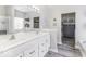 Bright bathroom featuring a dual sink vanity, large mirror, and a walk-in closet for added convenience at 8864 S Tibbs Ave, Indianapolis, IN 46217