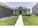 Inviting front porch featuring classic rocking chairs, brick facade, and manicured landscaping for a cozy welcome at 8864 S Tibbs Ave, Indianapolis, IN 46217