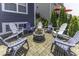 Paver patio with a fire pit encircled by six Adirondack chairs, surrounded by landscaping and blue siding at 8864 S Tibbs Ave, Indianapolis, IN 46217