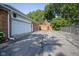 View of the backyard and driveway featuring brickwork details and basketball hoop at 9420 N Kenwood Ave, Indianapolis, IN 46260