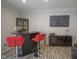 Finished basement bar area featuring a custom cabinet and two red bar stools at 9420 N Kenwood Ave, Indianapolis, IN 46260