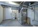 Basement space featuring painted block walls, furnace, and access to the outside at 9420 N Kenwood Ave, Indianapolis, IN 46260