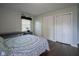 Bedroom with hardwood floors, natural light, storage closet, and blue patterned bedding at 9420 N Kenwood Ave, Indianapolis, IN 46260