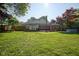 Expansive backyard featuring a well-maintained lawn, a deck, and lush landscaping surrounding the property at 9420 N Kenwood Ave, Indianapolis, IN 46260