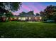 Back exterior view of the home and the expansive yard at twilight at 9420 N Kenwood Ave, Indianapolis, IN 46260