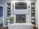 Close-up of the charming white brick fireplace with decorative shelving and a mounted television at 9420 N Kenwood Ave, Indianapolis, IN 46260
