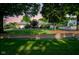 Charming single-story brick home with a beautiful lawn, mature trees, and a circular driveway at sunset at 9420 N Kenwood Ave, Indianapolis, IN 46260
