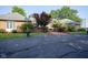 Charming brick home featuring manicured landscaping, beautiful bushes, and a paved driveway at 9420 N Kenwood Ave, Indianapolis, IN 46260