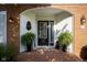 Covered front porch with brick flooring, potted ferns, a welcome mat, and decorative accents at 9420 N Kenwood Ave, Indianapolis, IN 46260