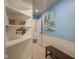 Hallway with white shelves, blue walls, white wainscoting, tile floors and small bench at 9420 N Kenwood Ave, Indianapolis, IN 46260