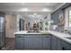 Open kitchen with cooktop, tile counters and view into living room area with sliding barn door at 9420 N Kenwood Ave, Indianapolis, IN 46260