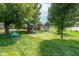 Lush backyard featuring a playset, trampoline, and swing set, creating an ideal space for outdoor fun at 10622 Penn Dr, Indianapolis, IN 46280