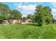 Spacious backyard with lush green lawn, mature trees, and a wooden deck perfect for outdoor entertaining at 10622 Penn Dr, Indianapolis, IN 46280