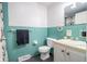 Charming bathroom featuring a turquoise tiled wall, vanity, and neutral wall above the tile at 10622 Penn Dr, Indianapolis, IN 46280