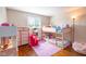 Bright bedroom featuring a bunk bed, playhouse, dresser, hardwood floors, and natural light from a window at 10622 Penn Dr, Indianapolis, IN 46280