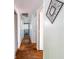 Hallway with hardwood flooring, white walls, and an art deco style mirror hanging on the wall at 10622 Penn Dr, Indianapolis, IN 46280