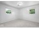 Neutral bedroom with grey carpet, white walls, and two windows at 10928 W Jackson St, Muncie, IN 47304