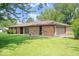 Side view of a beautiful brick ranch home with an attached garage and well-kept lawn at 10928 W Jackson St, Muncie, IN 47304