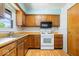 Traditional kitchen with wood cabinets, laminate countertops, and white appliances at 10928 W Jackson St, Muncie, IN 47304