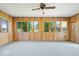 Sunroom featuring wood paneling, large windows, and ceiling fan at 10928 W Jackson St, Muncie, IN 47304