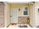 Inviting front door with a decorative mat, complemented by a charming flower pot and brick accents at 11320 Lynchburg Way, Indianapolis, IN 46229