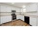Well-lit kitchen features stainless steel appliances, white cabinets, and wood flooring, creating a modern and inviting space at 11320 Lynchburg Way, Indianapolis, IN 46229