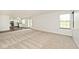 Bright living room with neutral carpet, white walls, and large windows providing ample natural light at 11320 Lynchburg Way, Indianapolis, IN 46229